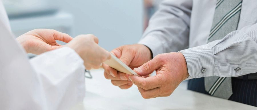 Eine Person unterhält sich mit einem Zahnarzt und übergibt ihm einige Buchhaltungsunterlagen